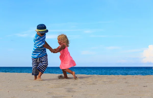 Chłopak i dziewczyna grać na plaży — Zdjęcie stockowe