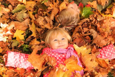 mutlu çocuklar eğleniyor sonbaharda yapraklar düşer