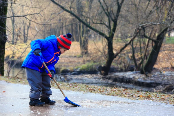 Niño pequeño limpiando hielo con pala — Foto de Stock