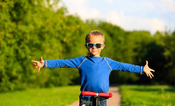 Glad liten pojke njuta av ridning skoter på sommaren — Stockfoto