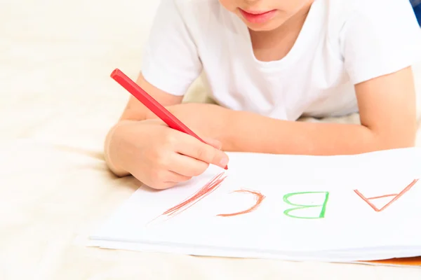 Маленький мальчик учится писать письма — стоковое фото