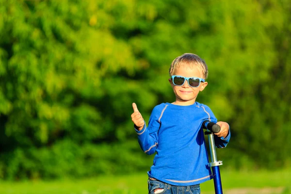 Felice ragazzino godere di equitazione scooter in estate — Foto Stock