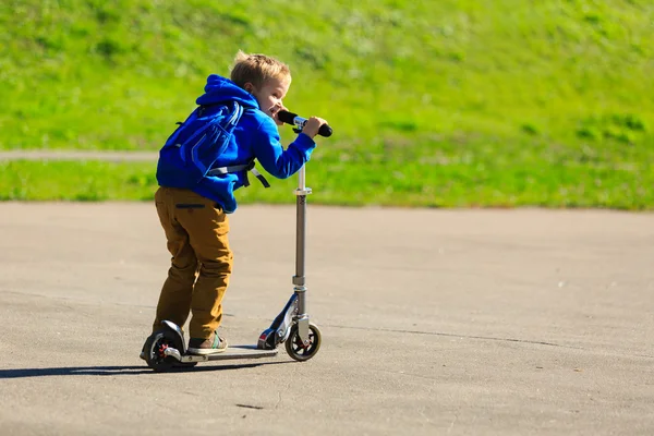 Boldog kis fiú lovaglás scooter, aktív gyerekek — Stock Fotó