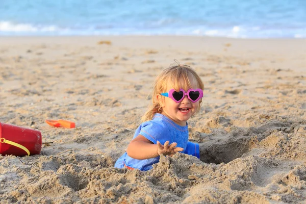 Holčička hrát s pískem na pláži — Stock fotografie