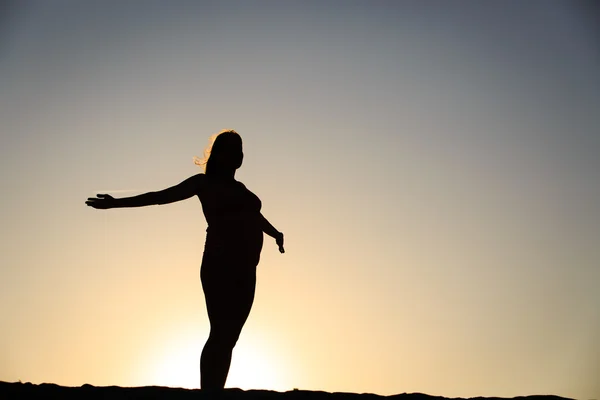 Siluet wanita hamil bahagia saat matahari terbenam — Stok Foto