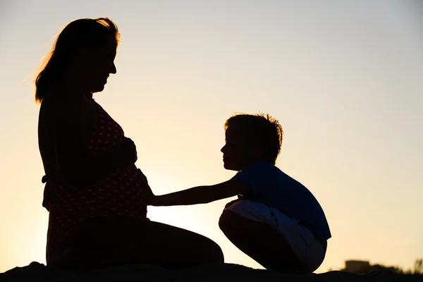 Silhueta de menino tocando barriga de mãe grávida — Fotografia de Stock