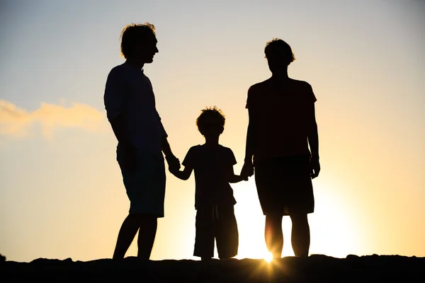 Glückliche Familie mit kleinem Jungen bei Sonnenuntergang — Stockfoto