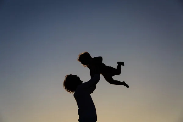 Πατέρας και μικρή κόρη σιλουέτες παίζουν στο ηλιοβασίλεμα — Φωτογραφία Αρχείου
