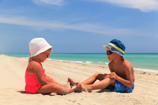 Liten pojke och flicka att ha kul på stranden — Stockfoto