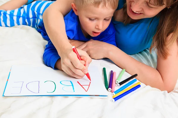 Mains de la mère et de l'enfant écrivant des lettres — Photo