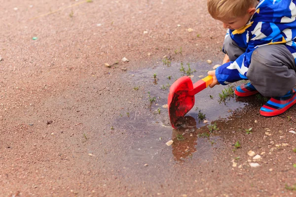 Child playing in water puddle — Stock Photo, Image