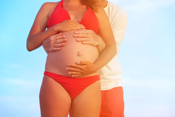 Feliz casal grávida na praia — Fotografia de Stock