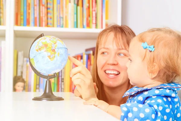 Maestra con niña apuntando al mundo en el aula —  Fotos de Stock