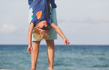 Baba ve küçük oğlu kumsalda oynarken