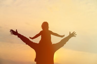 Baba ve küçük kızı omuzlarında gün batımı sky Çal