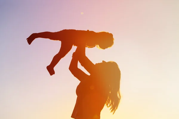 Moeder en kleine dochter spelen bij zonsondergang — Stockfoto