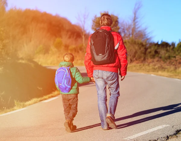 Οικογενειακά ταξίδια - πατέρας και γιος με Σακίδια με τα πόδια στο δρόμο — Φωτογραφία Αρχείου