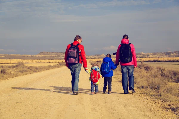 Rodina s dvěma dětmi, chůzi po malebné silnici, koncepce cestovního ruchu — Stock fotografie