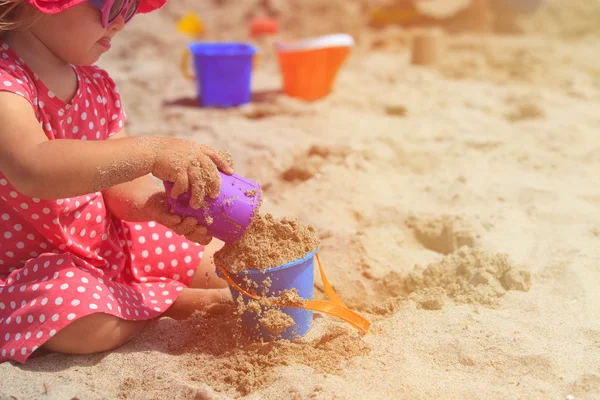Little girl play with sand on beach — Stock Photo, Image