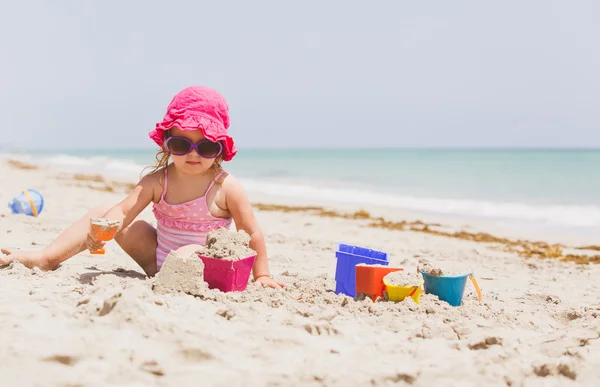 Mignonne petite fille jouer avec le sable sur la plage — Photo