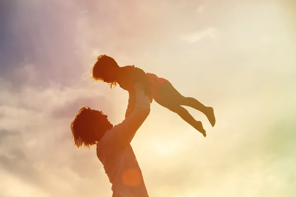 Apa és lánya kis játszani sziluettek a naplemente — Stock Fotó