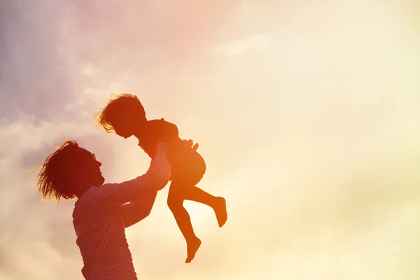 Père et petite fille jouent aux silhouettes au coucher du soleil — Photo