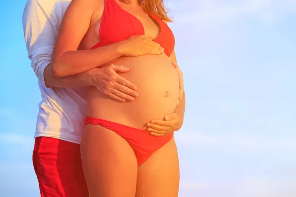 Lyckliga gravida par på stranden — Stockfoto