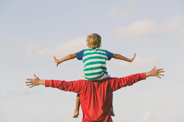 Happy father and son playing on sky — Stock Photo, Image
