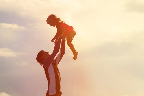 Padre e figlioletta giocano silhouette al tramonto — Foto Stock