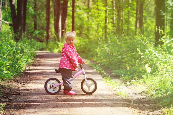 Bambina in sella alla bicicletta nella foresta estiva — Foto Stock