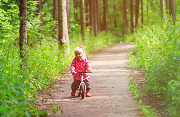 在夏季森林里的小女孩骑自行车 — 图库照片