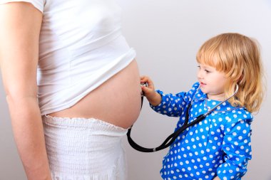 Kız stetoskop ile hamile anne kullanır.