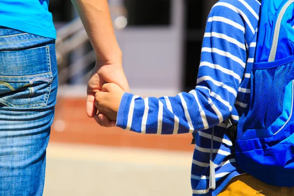 Мати тримає руку сина біля школи — стокове фото