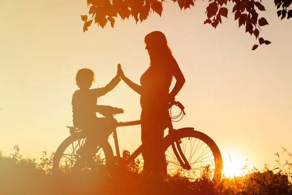 Silhuetas de mãe e filho de bicicleta — Fotografia de Stock