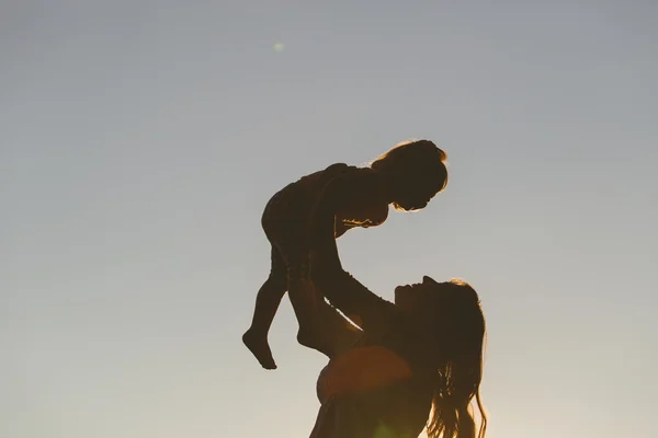 Mère et petite fille jouent au coucher du soleil — Photo