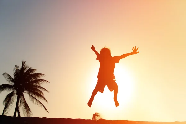 快乐的小男孩跳在日落海滩 — 图库照片