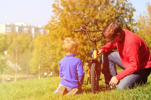 Pai e filho fixação de bicicleta no parque — Fotografia de Stock