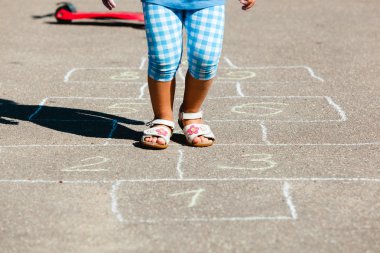 küçük kız oyun parkında seksek oynarken