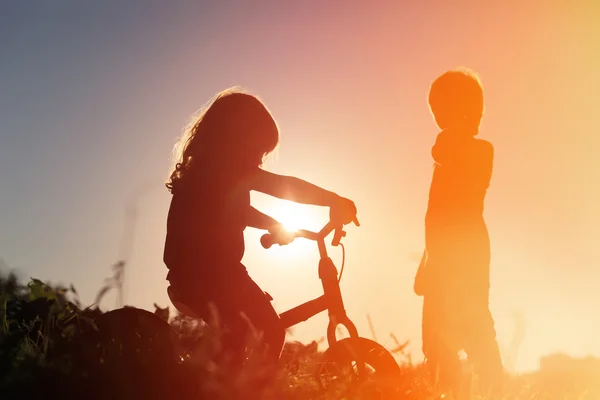 乗り自転車と夕焼け空の少年少女 — ストック写真