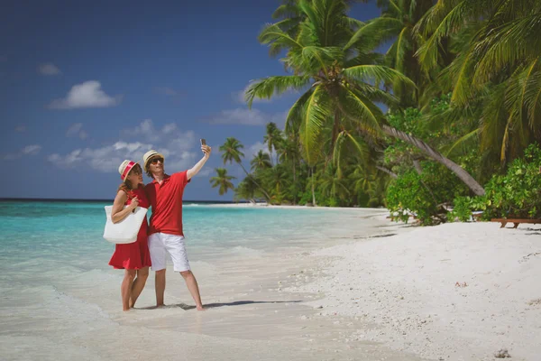 Joven feliz pareja haciendo un selfie en playa — Foto de Stock