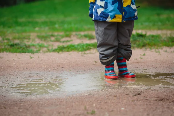 Child playing in muddy puddle — Stock Photo, Image