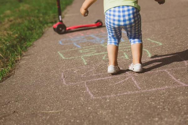 Kleines Mädchen spielt Hopscotch auf Spielplatz — Stockfoto