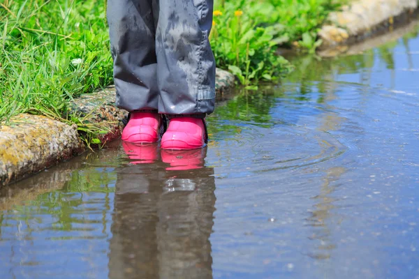 Дитина грає у водяній калюжі — стокове фото