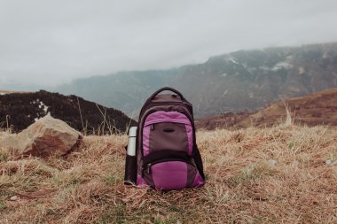 seyahat kavramı - sırt çantası ve termos içinde kış dağlar