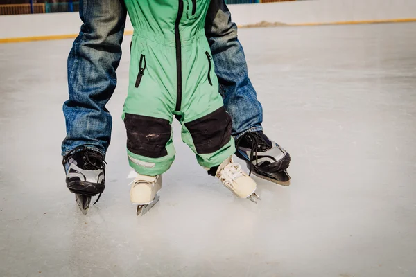 Отец и ребенок учатся кататься на коньках зимой — стоковое фото