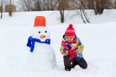 malá holčička budování sněhulák v přírodě