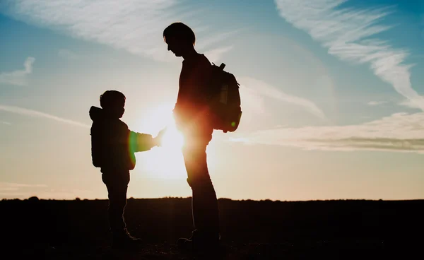 Familjens resa-far och son med ryggsäckar promenader i solnedgången — Stockfoto