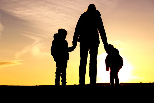 Familia viaje-madre y dos niños con mochilas al atardecer —  Fotos de Stock