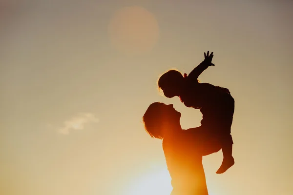 Padre e piccola figlia silhouette giocano al tramonto — Foto Stock