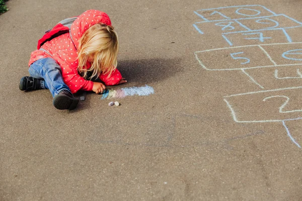 Kleines Mädchen zeichnet nach der Schule auf Asphalt — Stockfoto